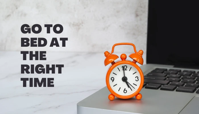 Orange alarm clock on laptop symbolizing bedtime routine